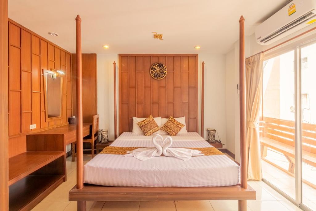 芭东海滩巴东莲花酒店的一间卧室,配有一张床,床上有一个弓
