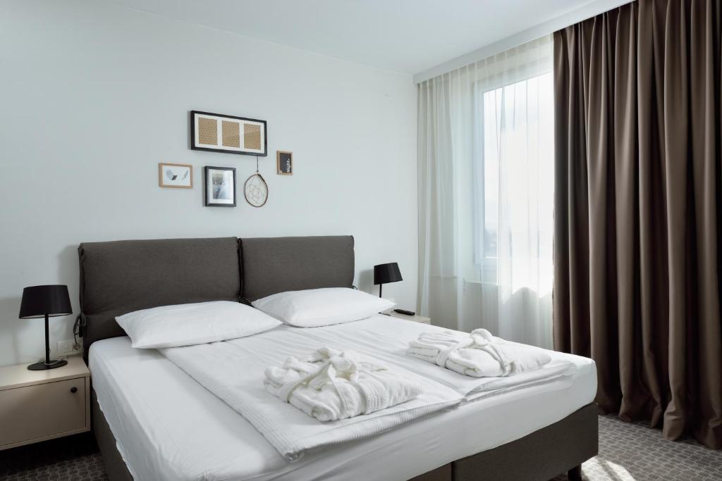 卢布尔雅那B&B Hotel Ljubljana Park的一间卧室配有带毛巾的床
