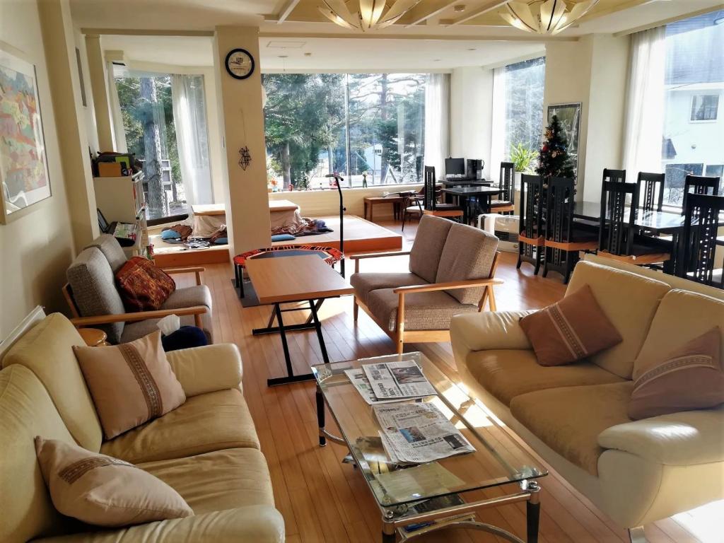 白马村K's House Hakuba Alps - Travelers Hostel的带沙发、椅子和桌子的客厅