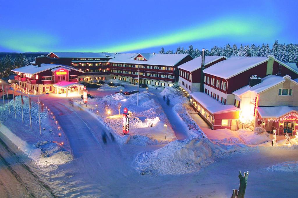 列维修鲁波罗酒店的一座小屋,上面有彩虹,上面有一座白雪覆盖的小镇