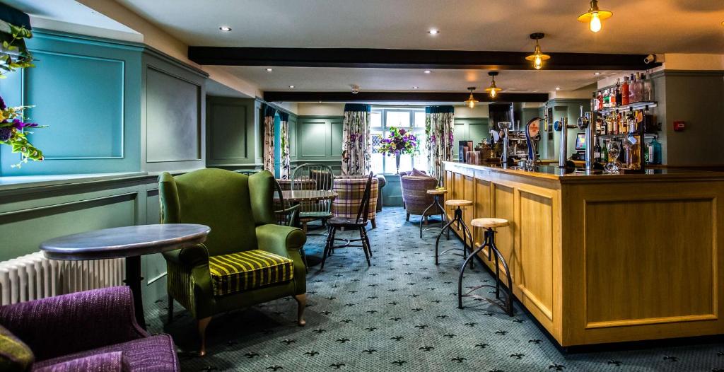 克利尔威尔The Wyndham Hotel的酒吧里设有绿色的椅子和桌子