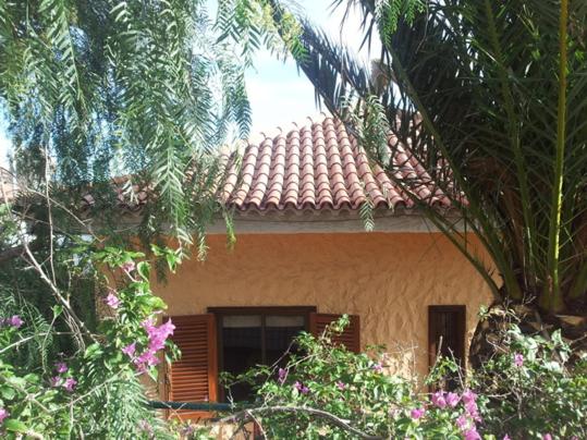 圣伊西德罗CASA FAMILIA - RELAX的一座房子,屋顶铺有瓷砖,还种植了树木和鲜花