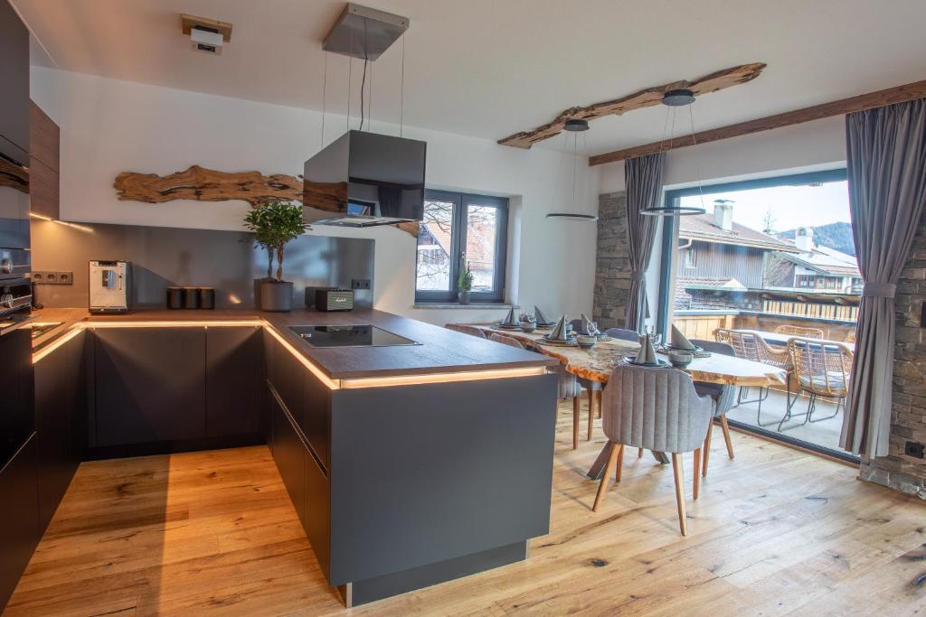 加尔米施-帕滕基兴Apartment Wood&Stone Alpi的厨房配有柜台和桌椅