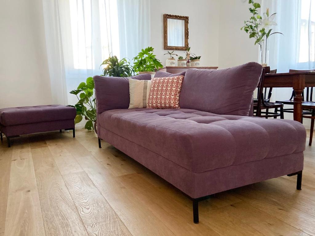佛罗伦萨Cantorial Charme的客厅配有一张紫色沙发,配有一张桌子