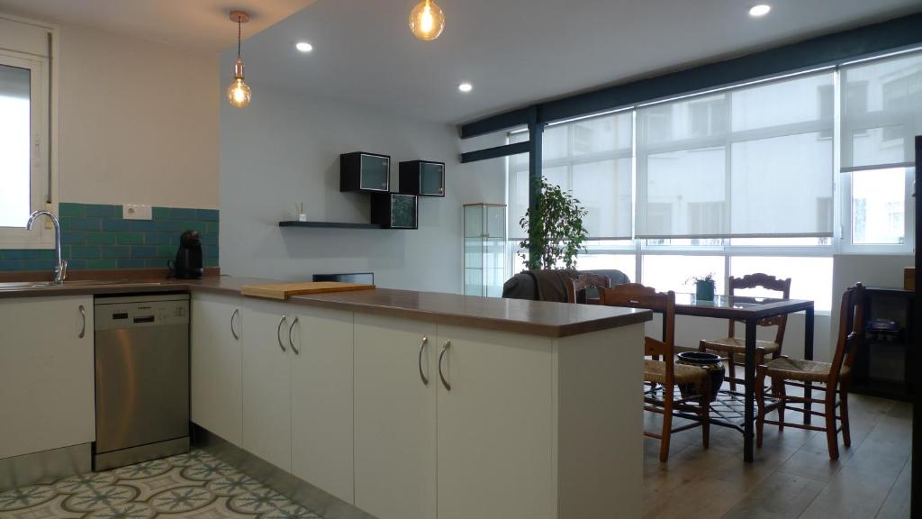 塞维利亚Living Triana House的厨房配有白色橱柜、桌子和用餐室。