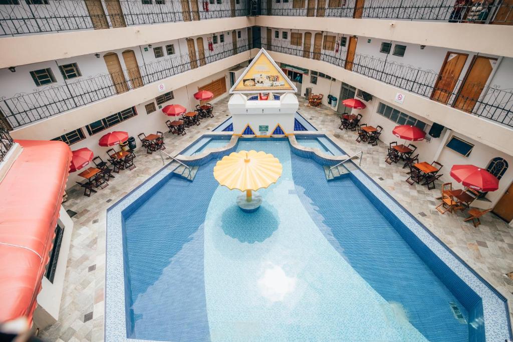 卡达斯诺瓦斯Hotel Triângulo的享有酒店游泳池的顶部景色,配有遮阳伞