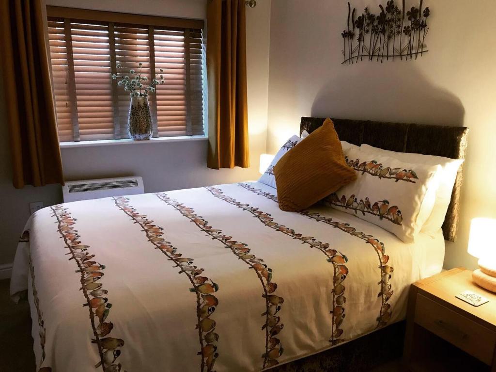 WombournClarabel's Guest House- The Nook的一间卧室配有一张带白色床单的床和一扇窗户。