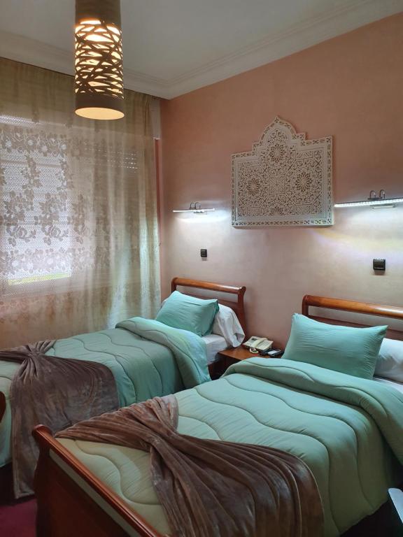 盖尼特拉Ambassy Hotel的客房设有两张床和窗户。