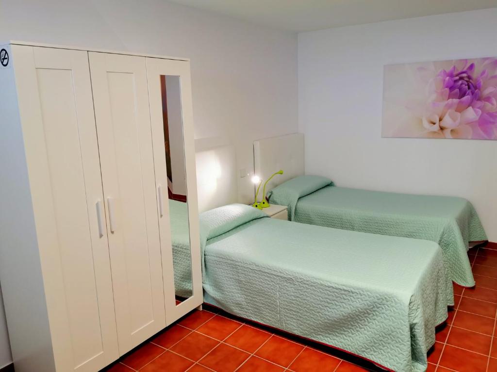 格拉纳迪利亚德亚沃纳Casa del Sur, en el Sur de Tenerife的一间小卧室,配有两张床和镜子