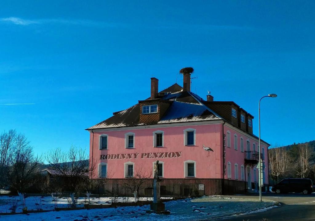 切尔韦纳沃达Penzion Mlýnický Dvůr的一座粉红色的旧建筑,上面有标志
