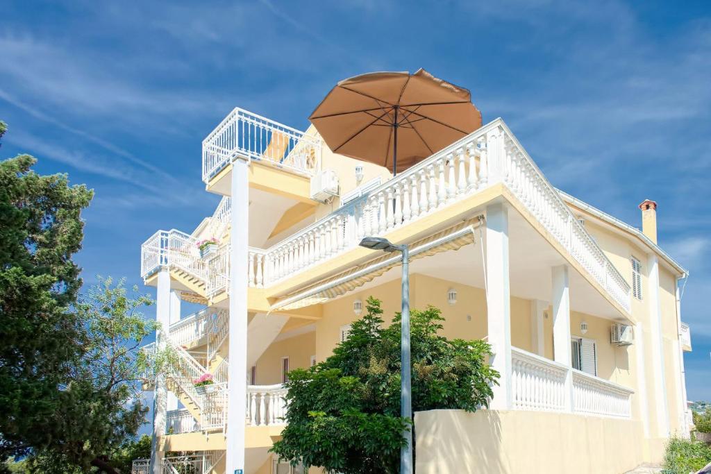 兹沃格谢Apartments and rooms Gojko - 50 m from the beach的一座黄色的大建筑,上面有雨伞