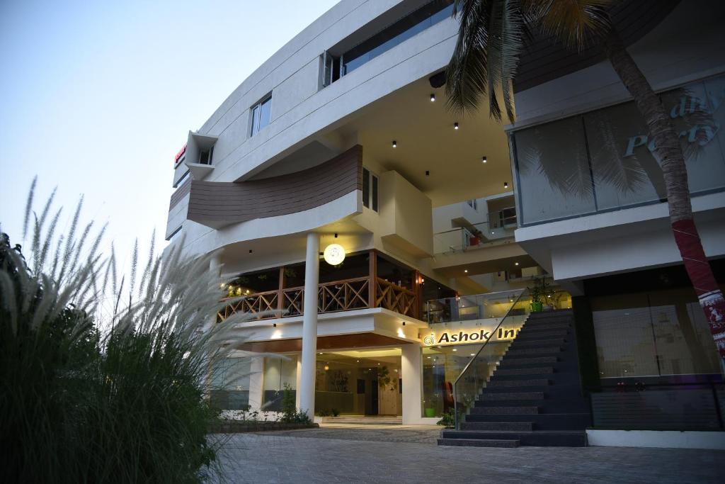 达文盖雷Ashok inn的一座大建筑,前面有棕榈树