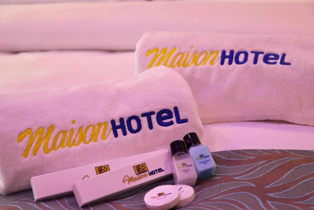 卡瓦延市MAISON HOTEL的一张带两条毛巾和两瓶指甲油的床