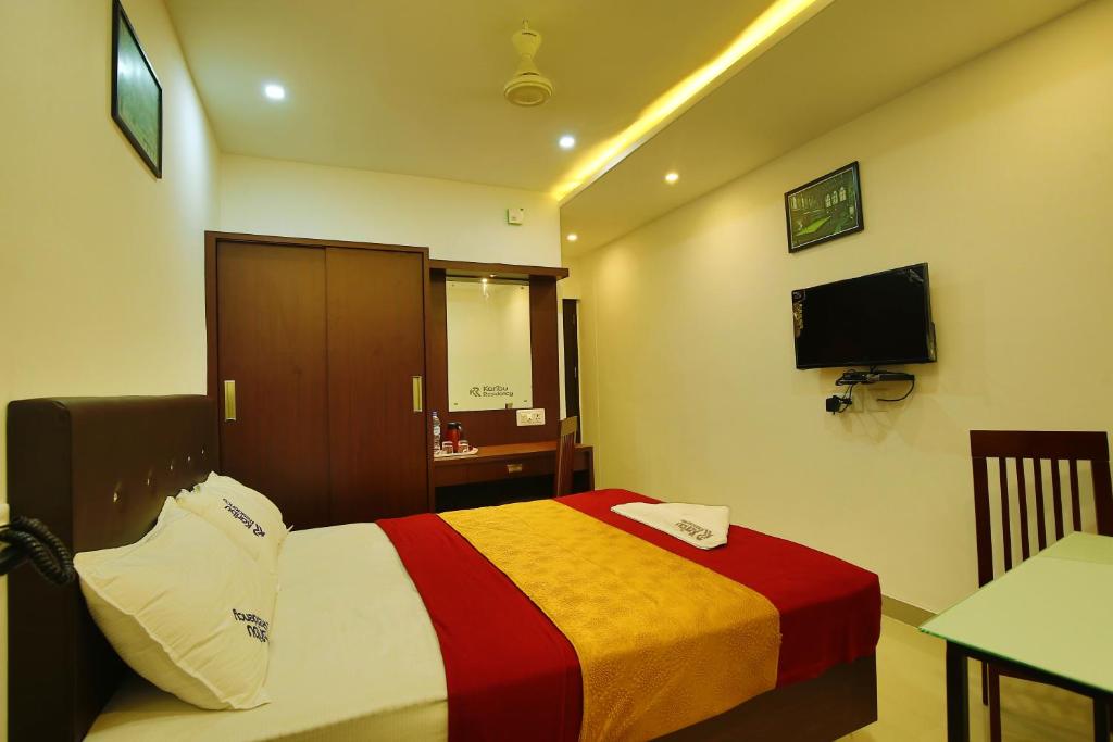 马拉普兰karibu Residency的酒店客房,配有床和电视