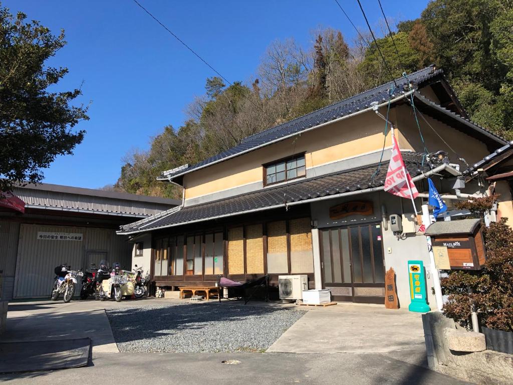 福山Rider & Guest House Kazeyoubi的停在前面的摩托车建筑