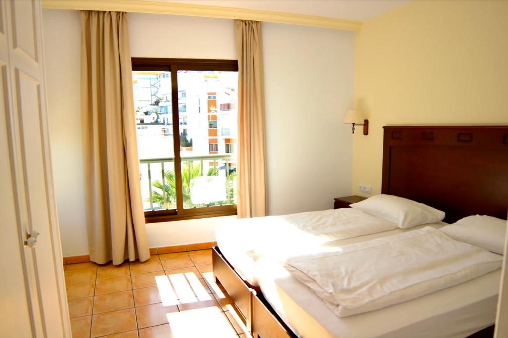 拉克鲁斯Hapimag Ferienwohnungen Puerto de la Cruz的一间卧室设有一张床和一个大窗户