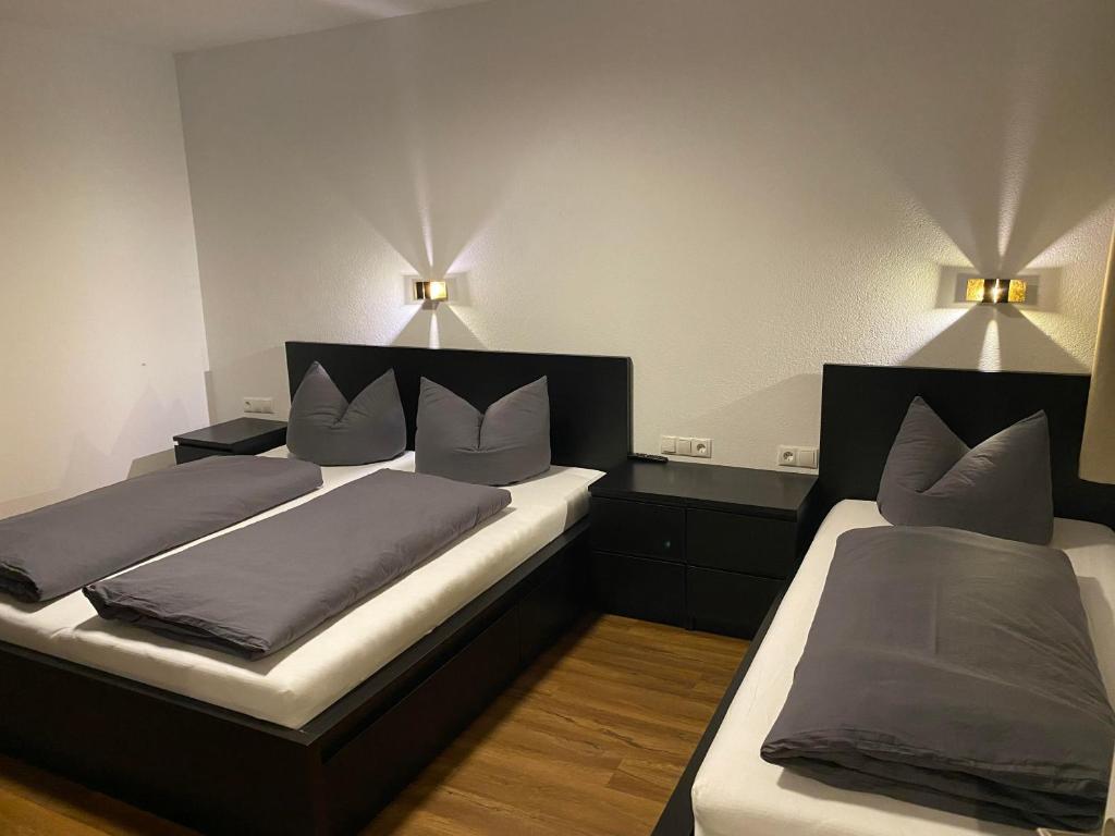 奥贝劳Kaiserblick Apartments的两张床位于带两盏挂在墙上的灯的房间