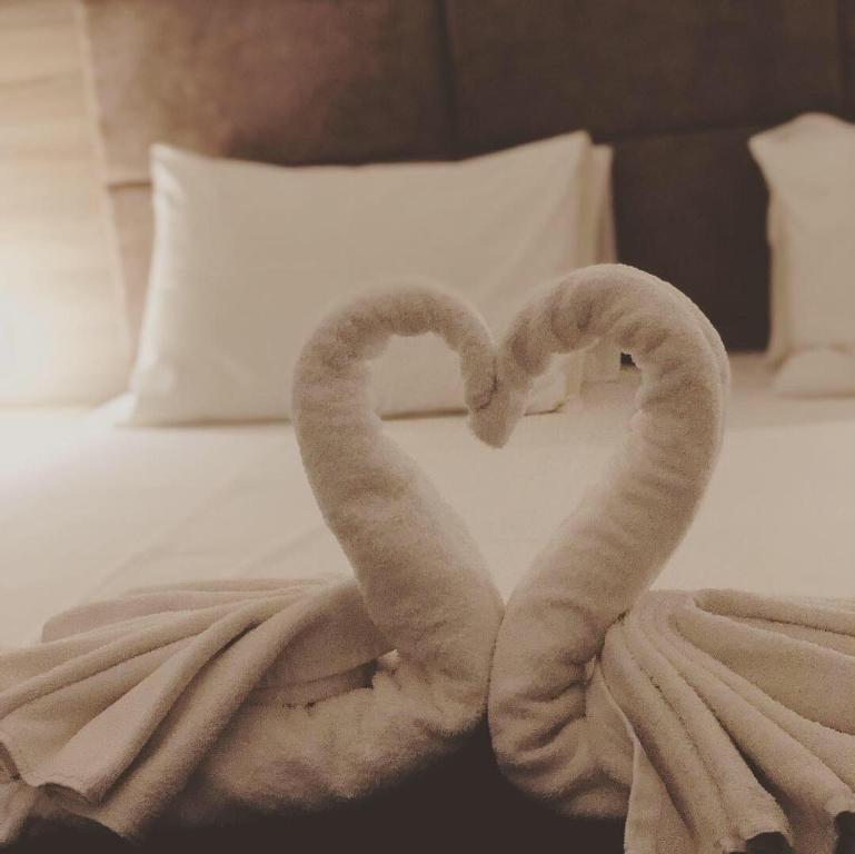 沃丽曼村拉格奥塔酒店的两条像心一样的毛巾,坐在床上