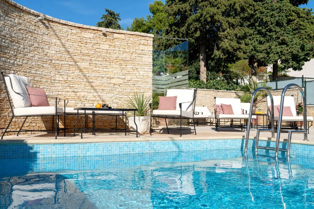迪斯诺历史帝斯诺酒店的砖墙旁的一个带椅子和桌子的游泳池