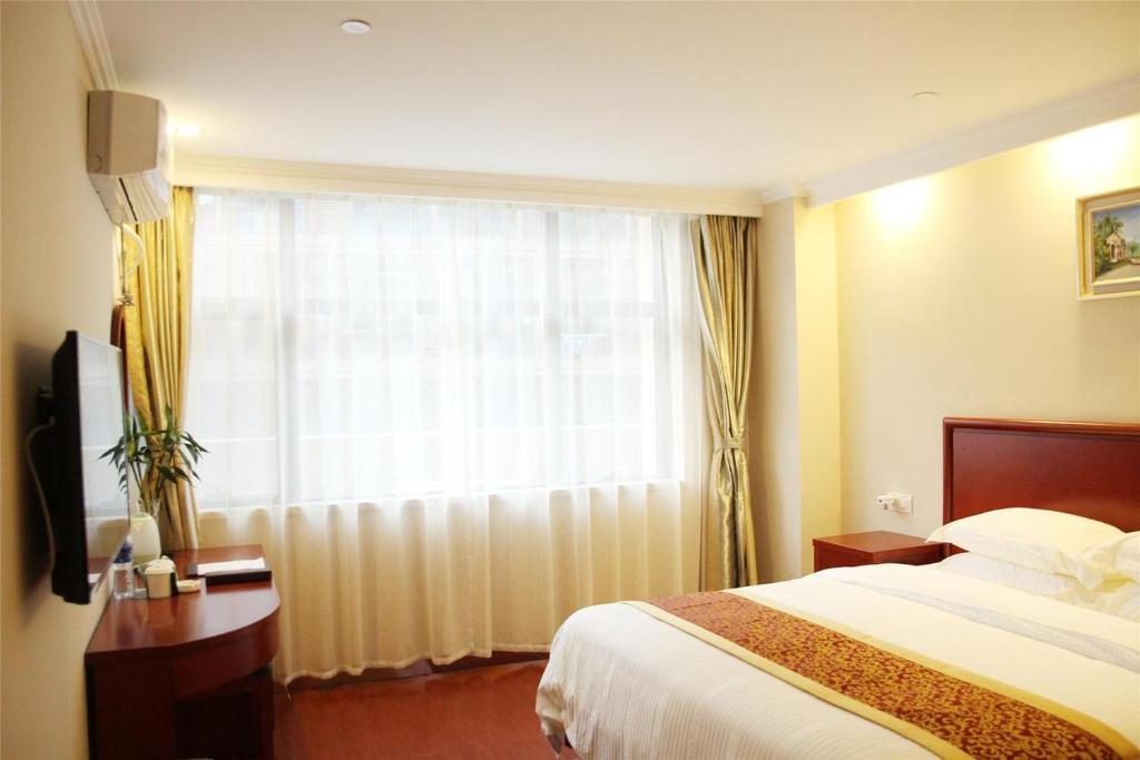 泗州格林豪泰宿州泗县汴河大道商务酒店的酒店客房设有床和窗户。