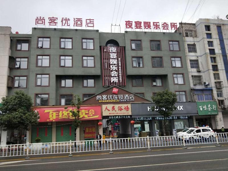 阜阳尚客优酒店安徽阜阳阜南县百货大楼店的街道一侧有标志的建筑