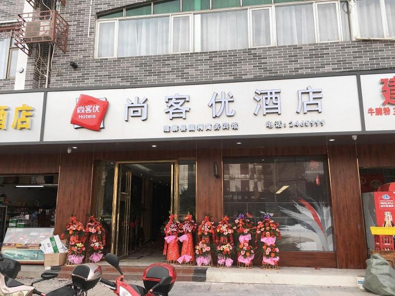 柳州尚客优酒店广西柳州鹿寨县广场店的一群穿着红色制服的人在商店前