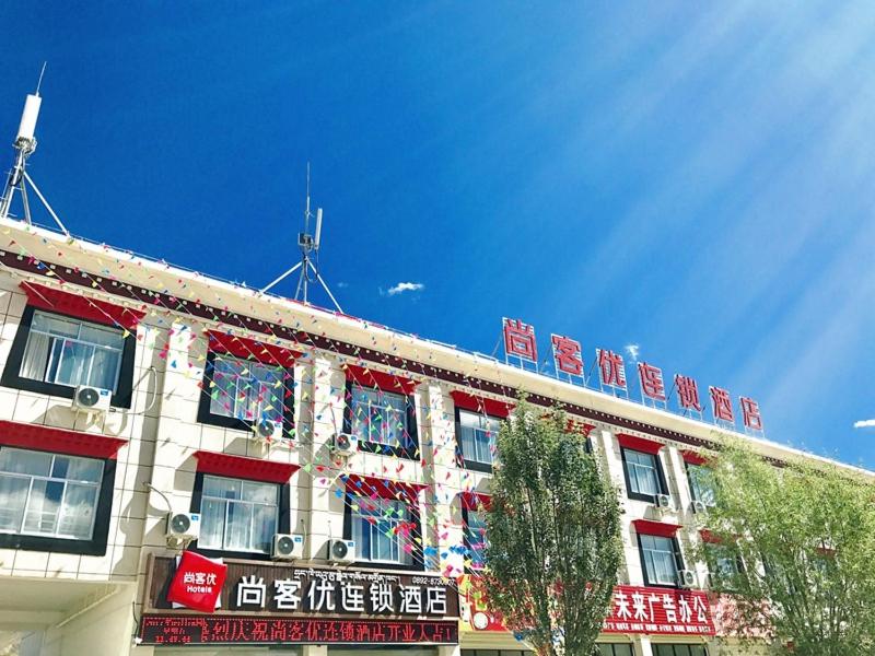 Kaika尚客优酒店西藏日喀则昂仁县县政府店的上面有红色和白色标志的建筑