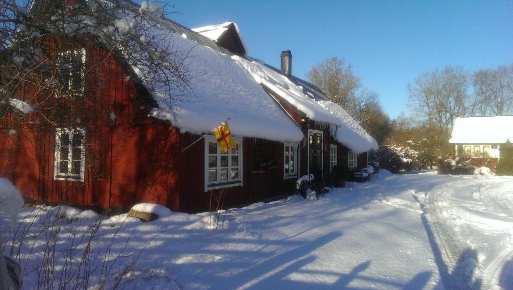 LjungbyhedRögnaröd 4604的屋顶上白雪的红色谷仓