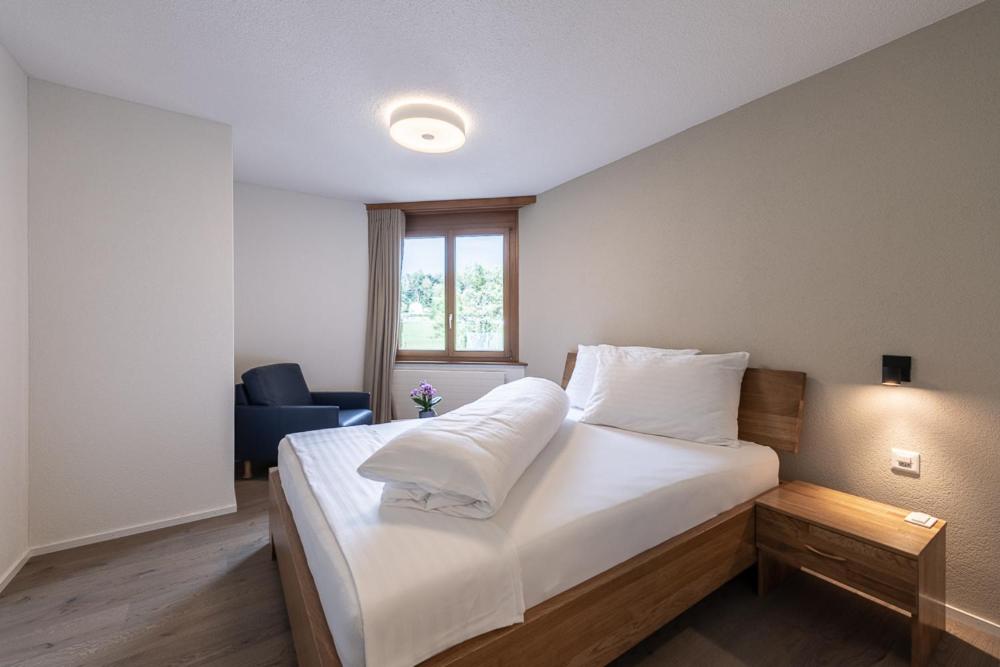 RütiNoah Hotel的一间卧室配有一张带白色床单的床和一扇窗户。