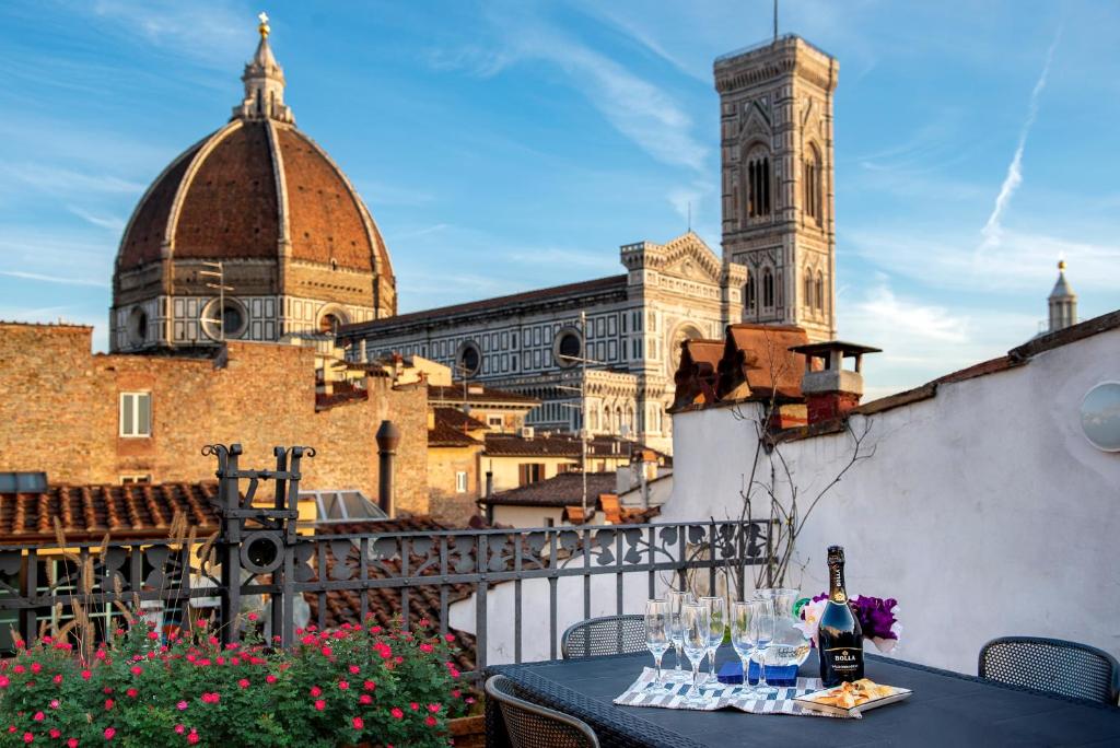 佛罗伦萨Borgo San Lorenzo Attico Duomo的阳台的桌子上摆放着酒杯