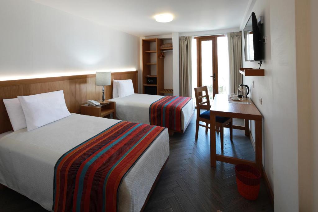 阿雷基帕圣奥古斯丁波萨达德尔修道院酒店的酒店客房配有两张床和一张书桌