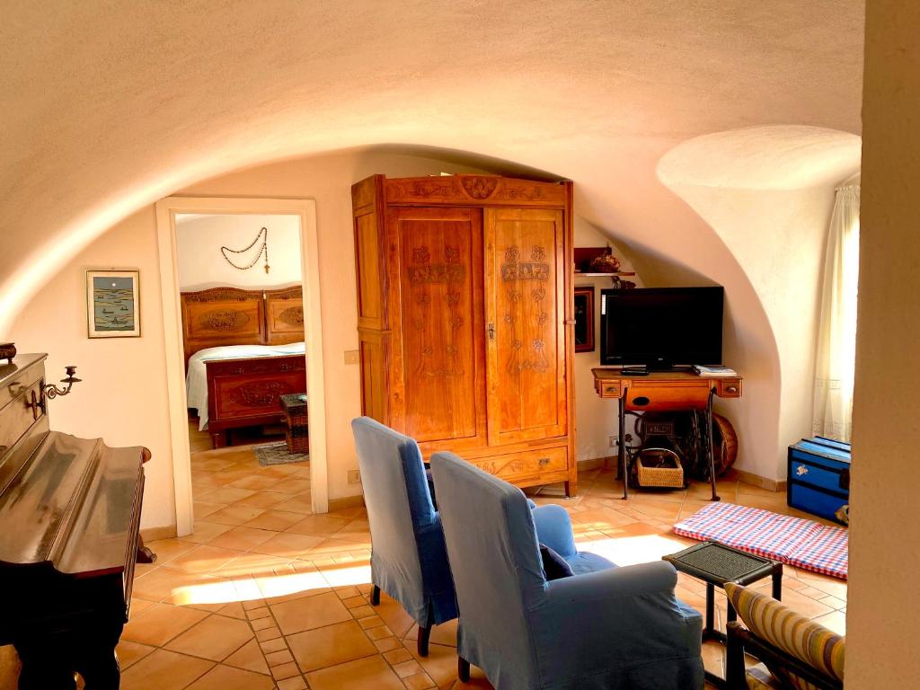 切尔沃Casa del 1400 nell'antico Borgo di Cervo的客厅配有电视、沙发和椅子
