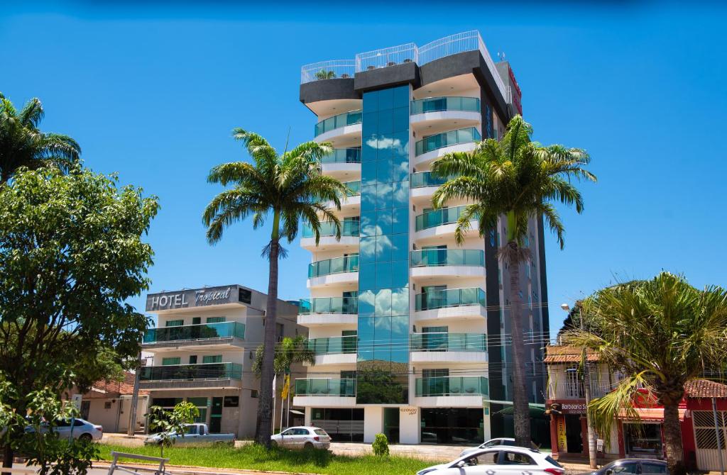 帕拉卡图Hotel Eldorado的一座高大的建筑,前面有棕榈树