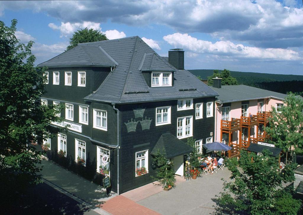 弗劳恩瓦尔德德赖皇冠酒店的一座黑色的大房子,外面的人坐在里面