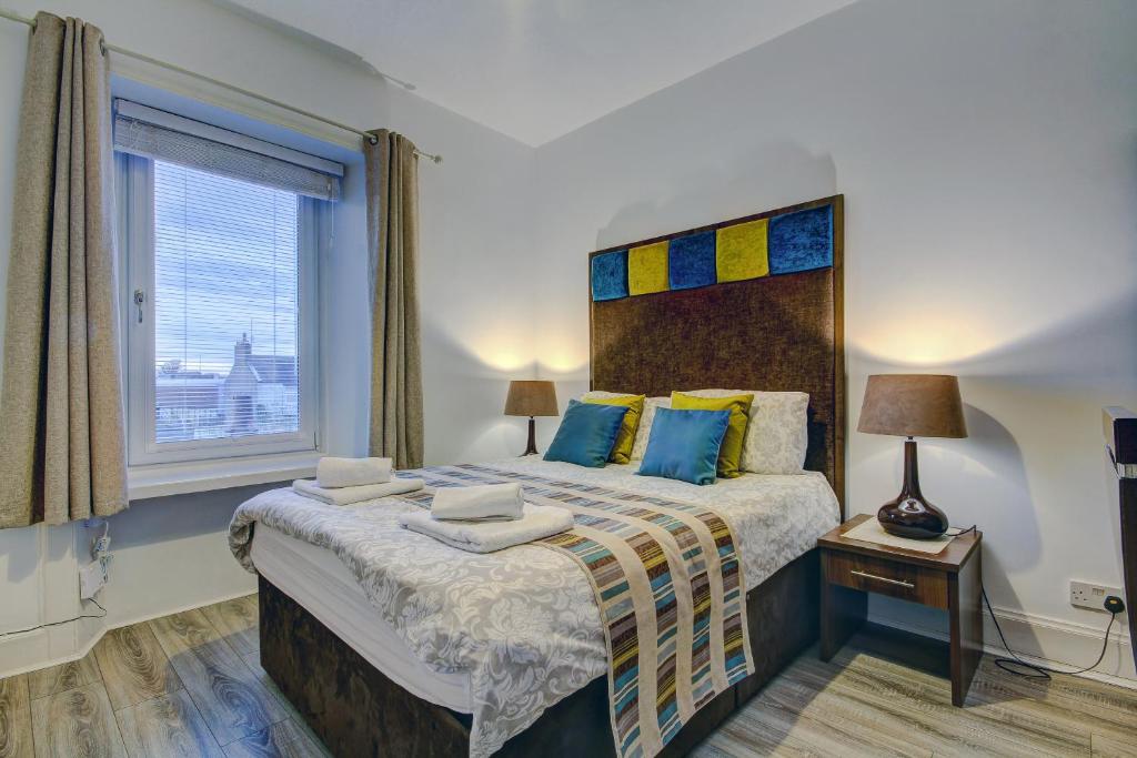 普雷斯蒂克Garden Gate Upper Apartment的一间卧室设有一张大床和一个窗户。
