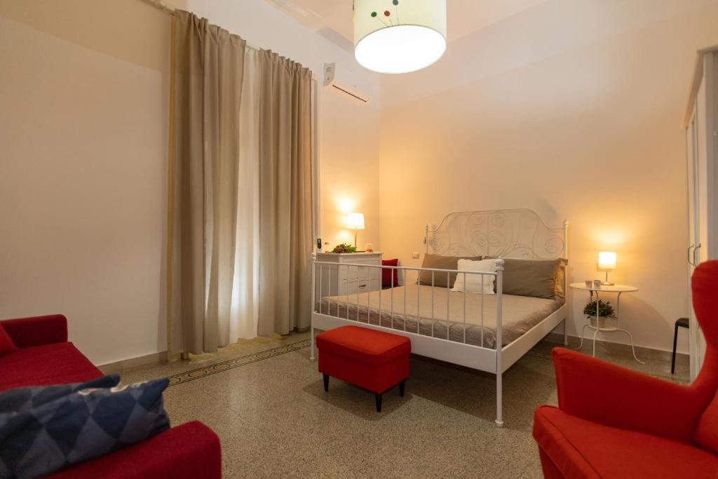 萨莱诺Sichelgaita Apartment的一间小卧室,配有一张床和一把红色椅子