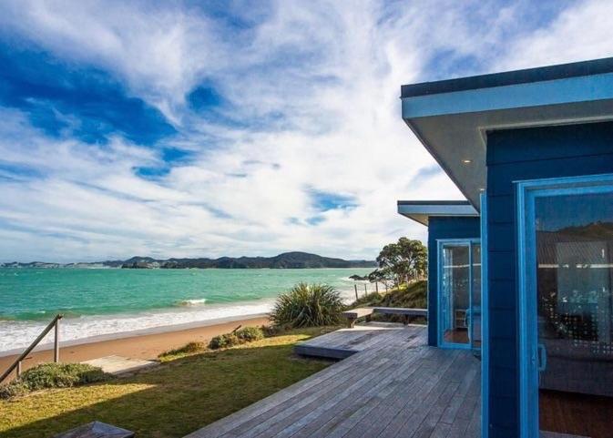 图图卡卡Shoreside - Tutukaka Holiday Home的蓝色的别墅,享有海滩美景