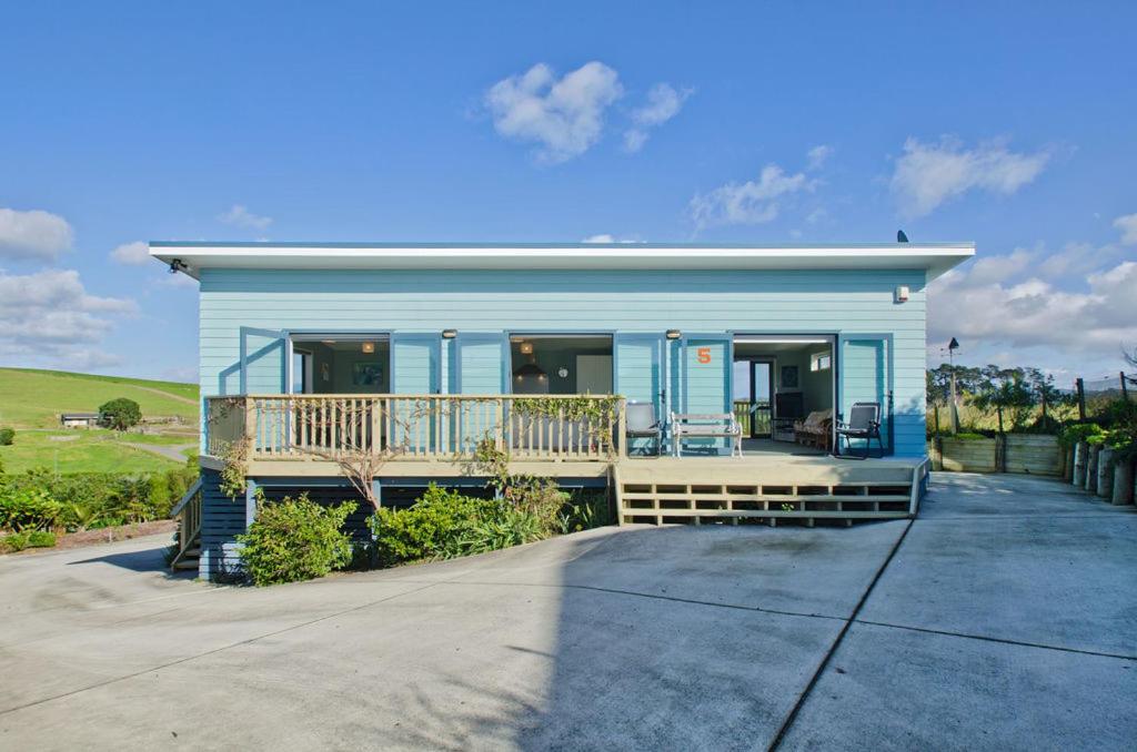 怀普The Blue Cottage with WiFi- Waipu Holiday Home的蓝色的房子,设有门廊和阳台