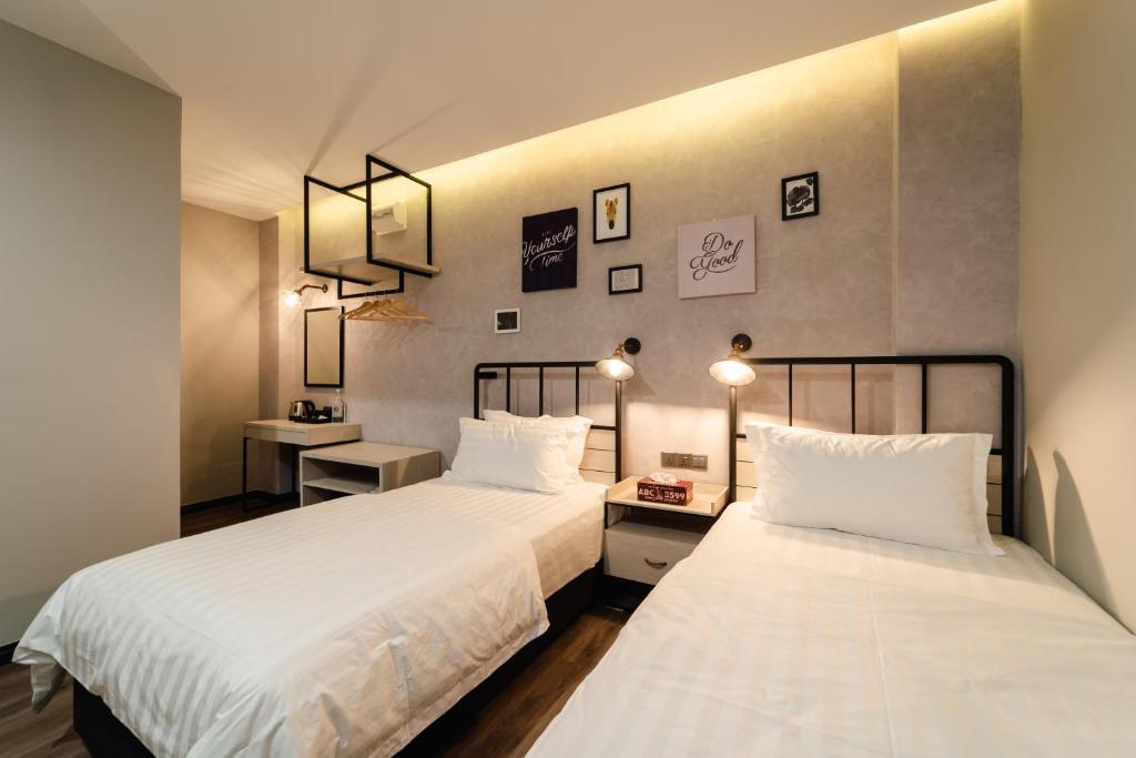 斗湖SVOK Hotel的配有两盏灯和两张sidx sidx单人床的客房内的两张床