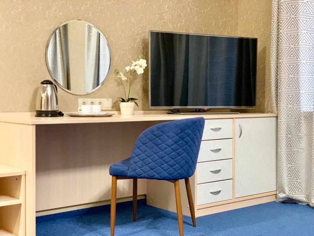 科斯特罗马科斯特罗马商务酒店的一张桌子、一台电视和一张蓝色椅子