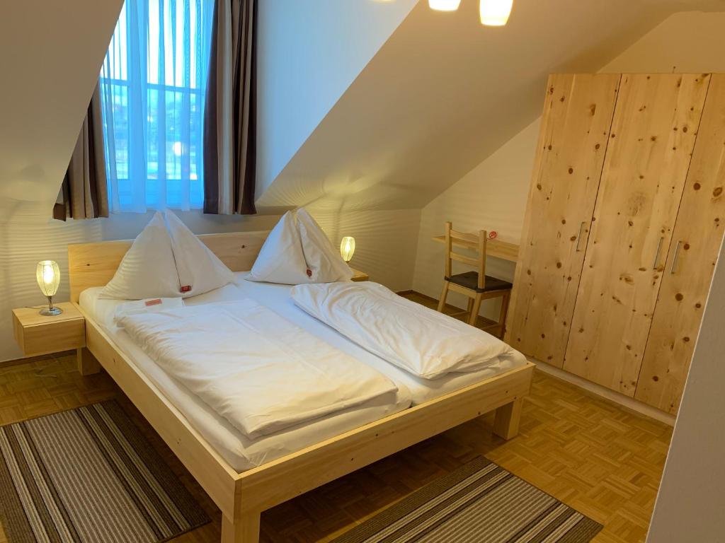 Feldkirchen bei Graz费尔德吉尔纳霍夫宾馆的一间卧室配有一张带白色床单的大床
