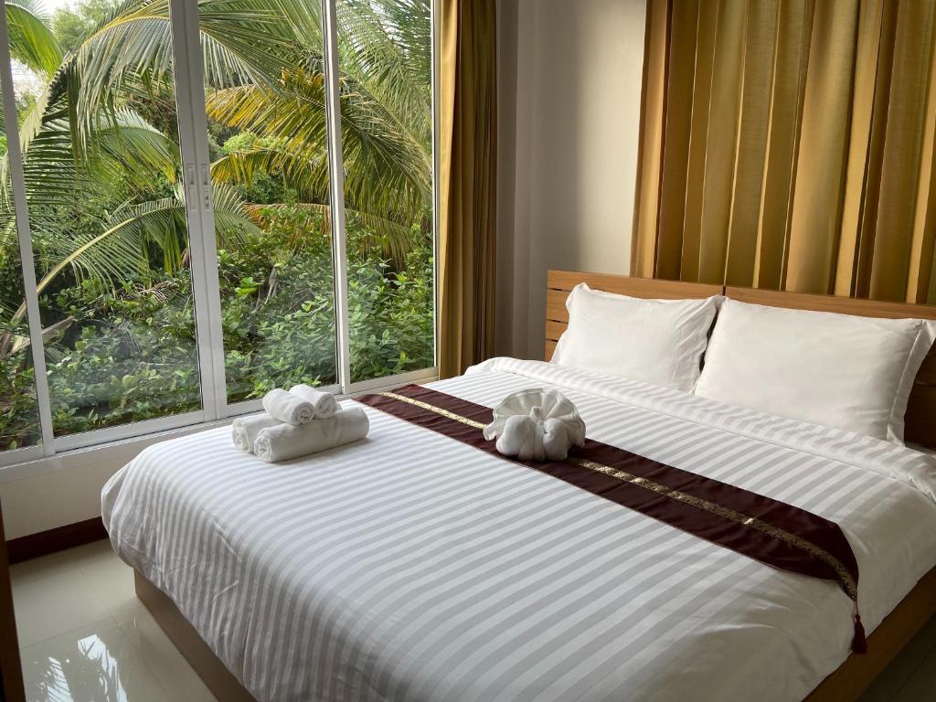 北标府ร่มปาล์มรีสอร์ท สระบุรี Rompalm Saraburi的一间卧室配有一张大床和毛巾
