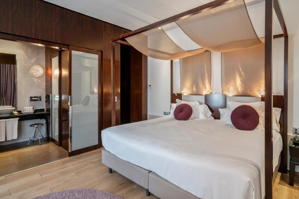 瓦伦西亚文奇宫殿酒店的一间带白色大床的卧室和一间浴室