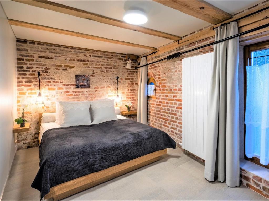 里加瑞克斯韦尔老里加宫酒店的砖墙卧室,配有一张床和一个窗户