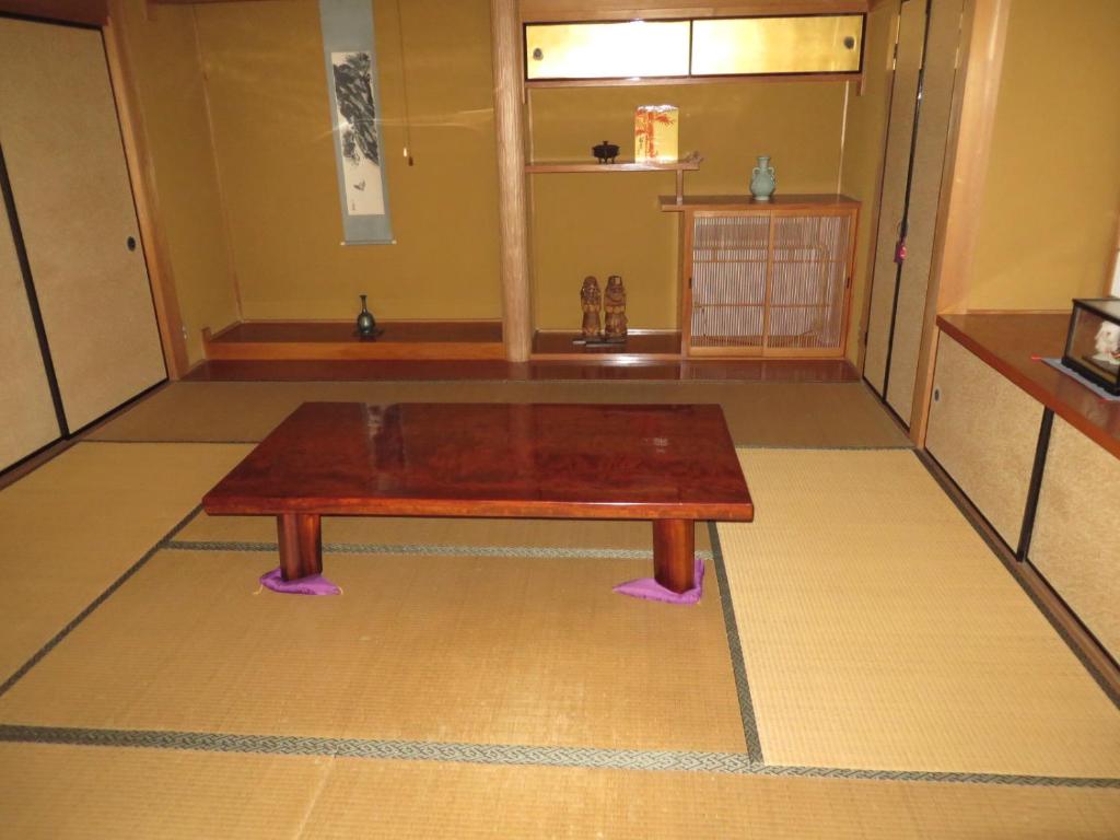 岐阜ゲストハウス山本的一张木桌,坐在地板的顶部