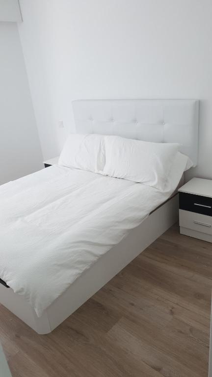 La PinillaApartamento estacion de esqui la pinilla的一张带白色床单和白色墙壁的床