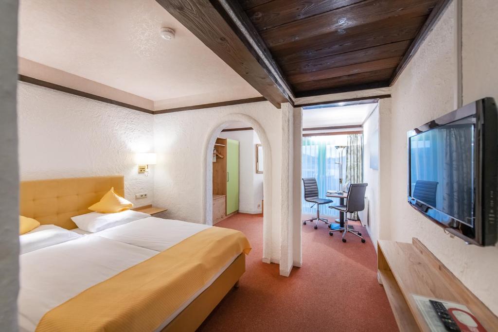 科布伦茨CONTEL Hotel的配有一张床和一台平面电视的酒店客房
