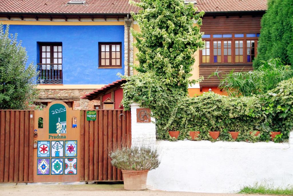 卢安科Casas Rurales Pradina I y II的蓝色房子,带栅栏和植物