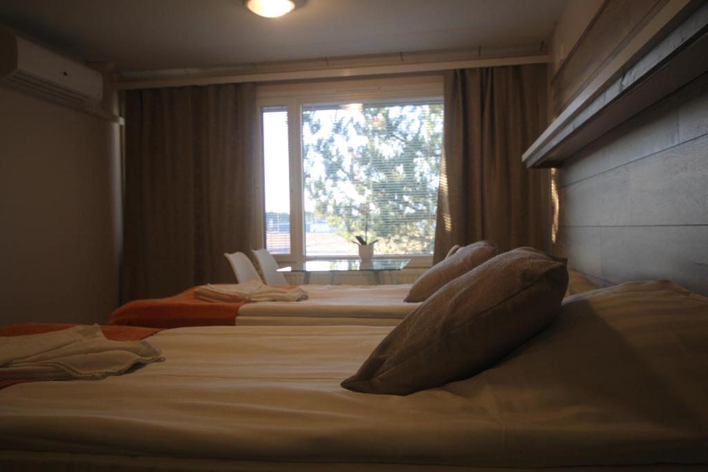 海尔迈哈尔玛嘉实坎洛玛公寓酒店的一间卧室设有两张床和一个美景窗户。
