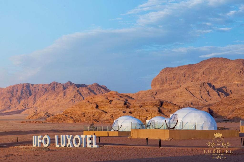 瓦迪拉姆Wadi Rum UFO Luxotel的沙漠中的两个圆顶,以山脉为背景
